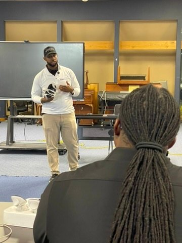 Yaphet speaking on stage at Rizewell